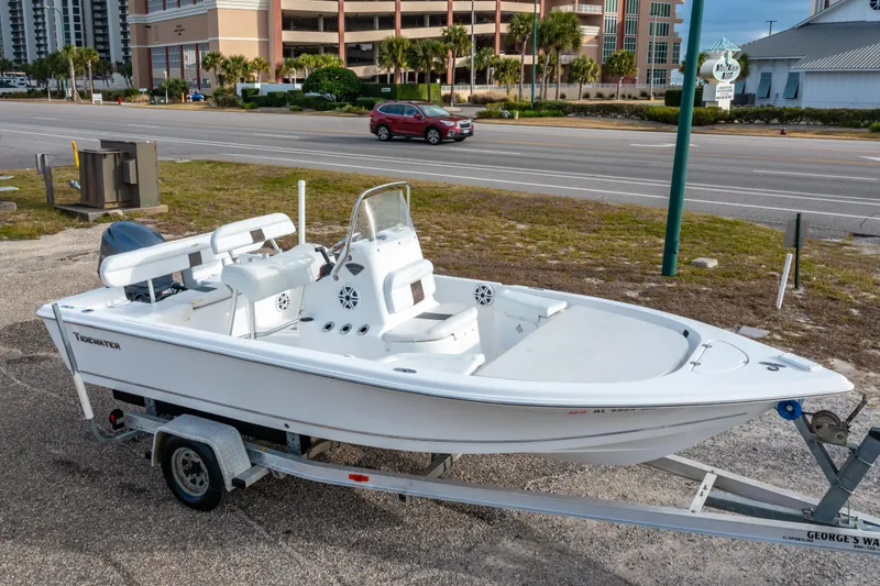The Image of 2013 Tidewater 1900 Bay Max boat on trailer, parked near a road with buildings in background. - 0