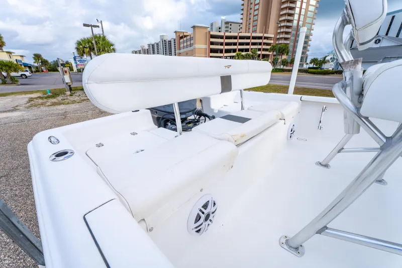 Slide: The Image of 2013 Tidewater 1900 Bay Max boat interior with seating and speakers, parked near buildings. - 15