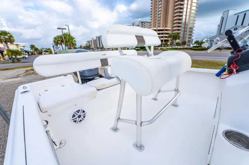 Slide: The Image of 2013 Tidewater 1900 Bay Max boat interior with seating and console, coastal background. - 16
