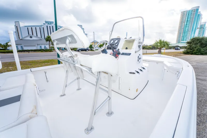 Slide: The Image of 2013 Tidewater 1900 Bay Max boat interior with console and seating, near modern buildings. - 20