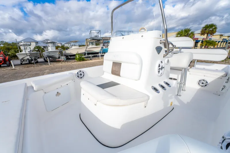 Slide: The Image of 2013 Tidewater 1900 Bay Max boat interior with seating and console, parked outdoors. - 25