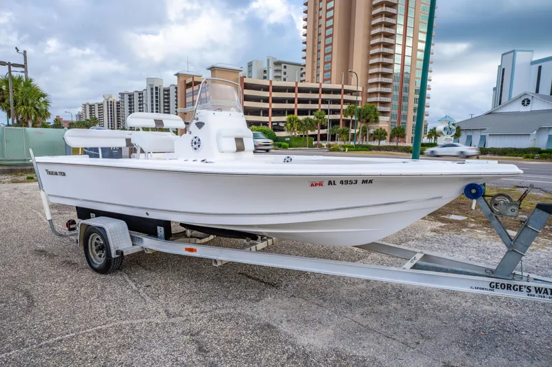 Slide: The Image of 2013 Tidewater 1900 Bay Max boat on trailer, urban background, cloudy sky. - 3