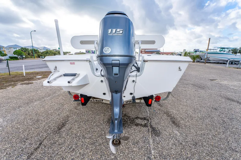Slide: The Image of 2013 Tidewater 1900 Bay Max boat with 115 horsepower outboard motor, parked outdoors. - 8