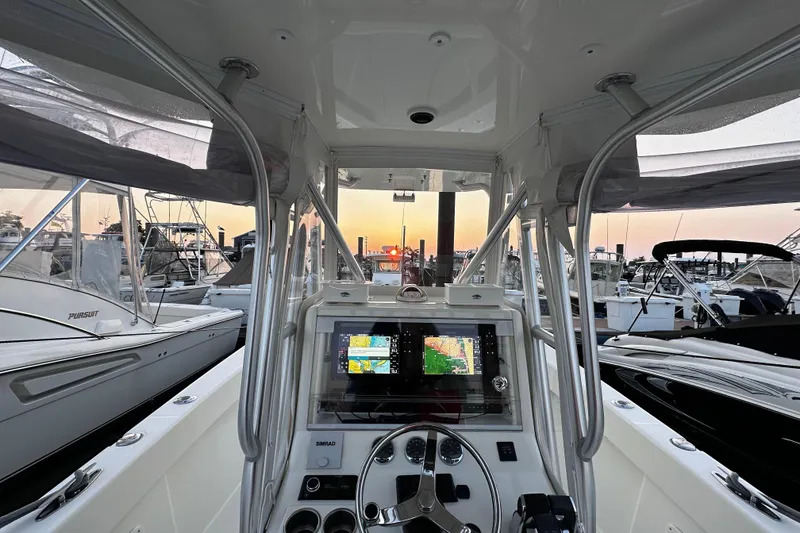 Slide: The Image of 2014 SeaVee 290B boat cockpit with navigation screens at sunset in marina. - 3