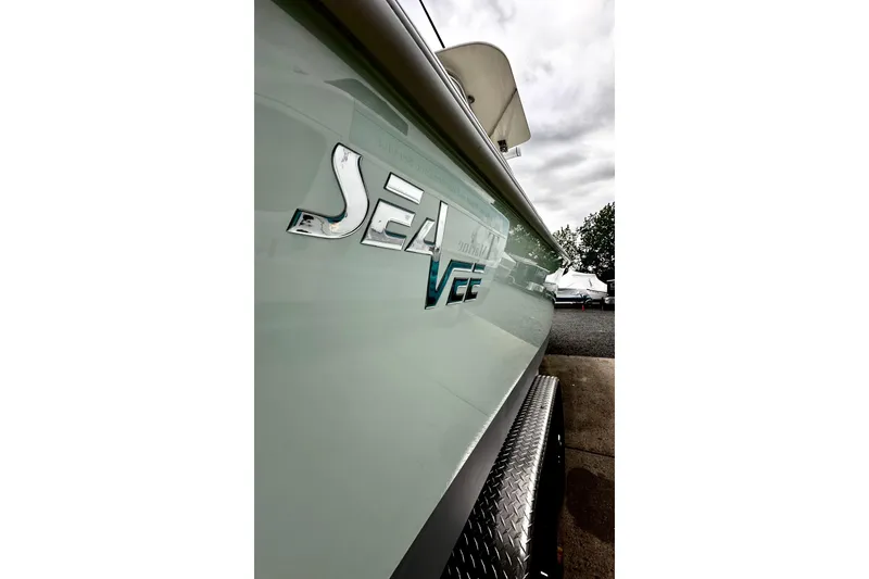Slide: The Image of 2014 SeaVee 290B boat side view with logo, parked outdoors. - 9