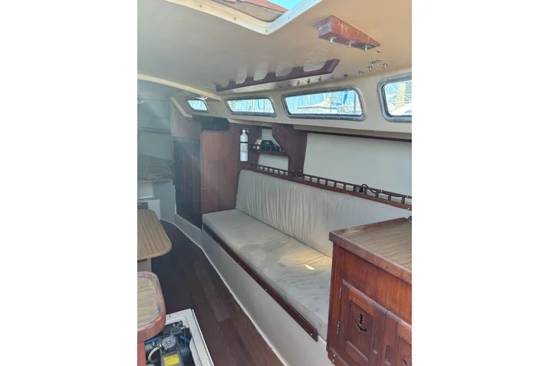 Slide: The Image of Interior of 1980 Catalina 30 sailboat with wooden furnishings and cushioned seating. - 12
