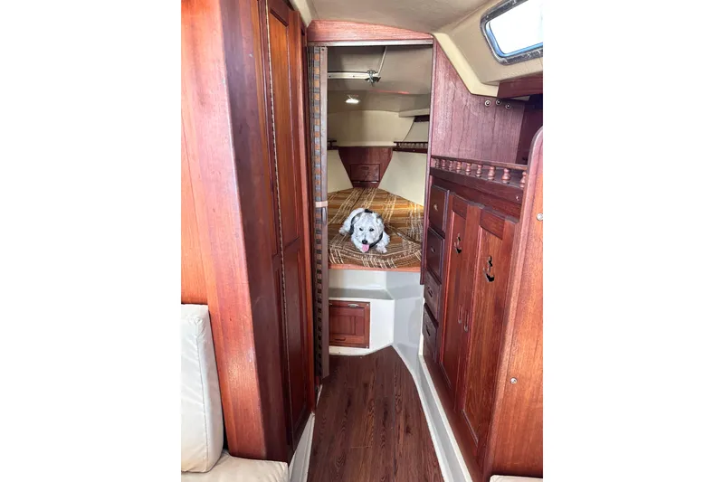 Slide: The Image of 1980 Catalina 30 sailboat in marina, under boat lift, clear blue sky. - 17