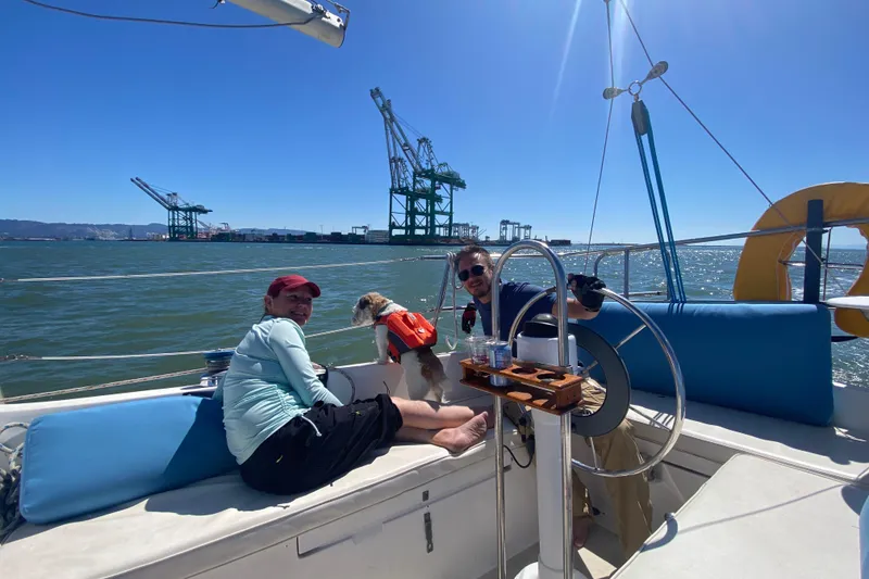 Slide: The Image of Group enjoying a sunny day on a 1980 Catalina 30 sailboat, with city skyline in background. - 22
