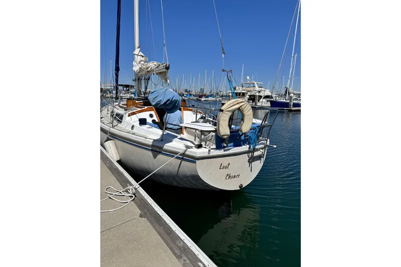 Slide: The Image of 1980 Catalina 30 sailboat docked in marina under clear blue sky. - 8
