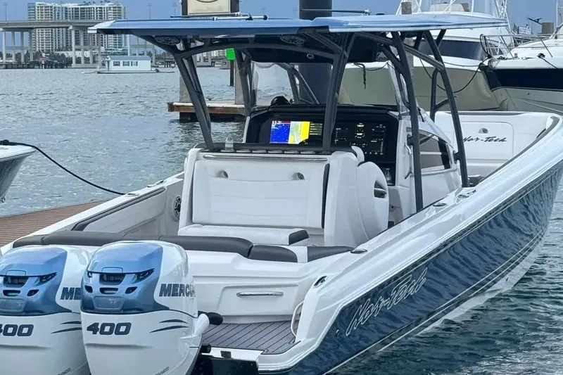 The Image of 2023 Nor-Tech 340 Sport Open Center Console boat cruising on a sunny day. - 0