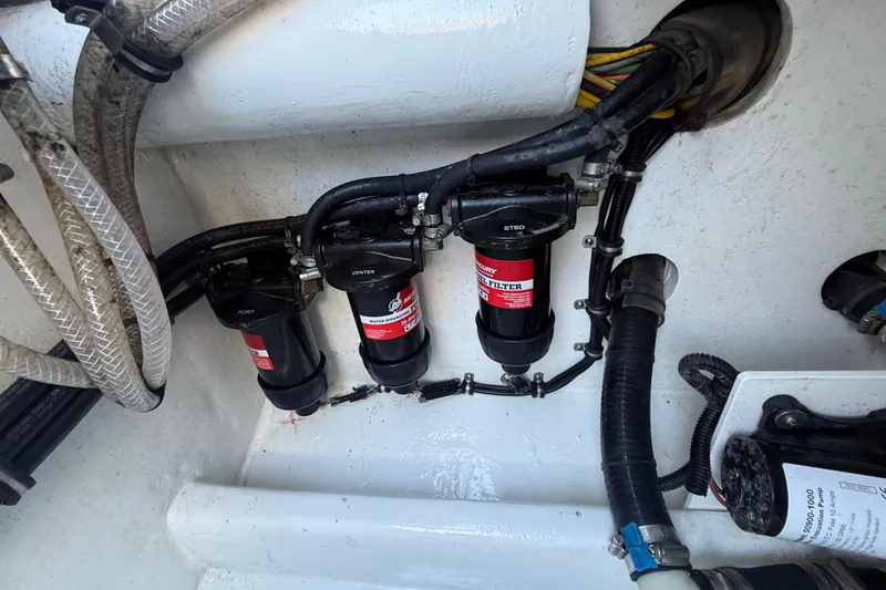 Slide: The Image of Engine compartment of 2023 Nor-Tech 340 Sport Open Center Console with fuel filters and hoses. - 18
