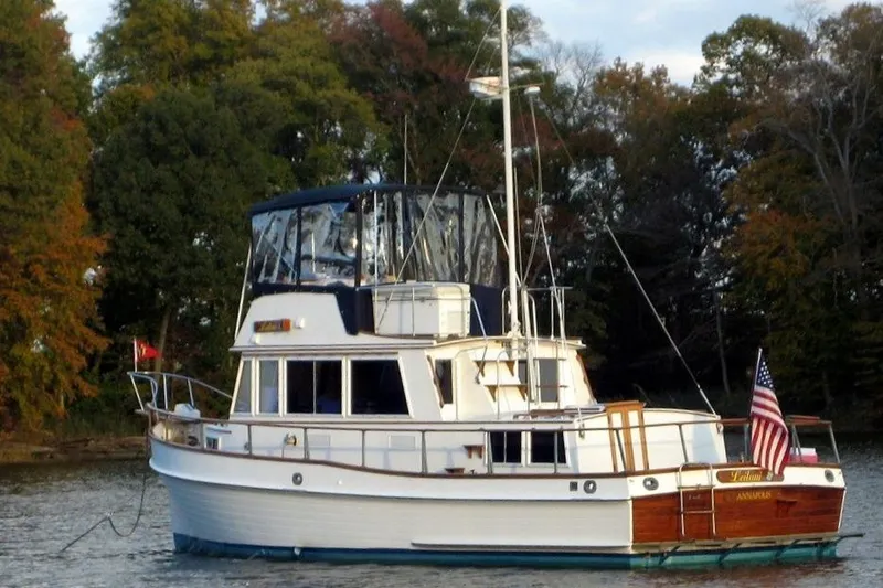 Slide: The Image of 1981 Grand Banks 36 Classic yacht anchored on a serene lake with autumn trees. - 3