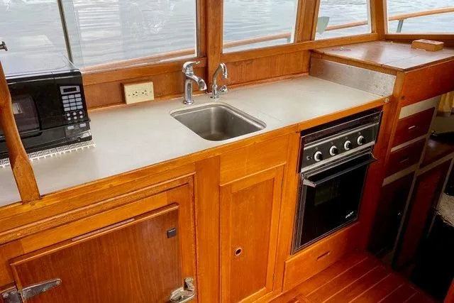 Slide: The Image of 1981 Grand Banks 36 Classic yacht kitchen with sink, stove, and microwave. - 30