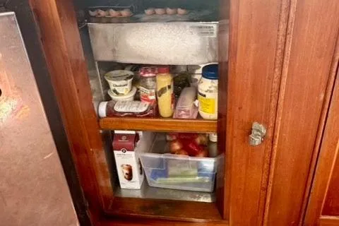 Slide: The Image of Wooden cabinet with assorted food items on a 1981 Grand Banks 36 Classic boat. - 31