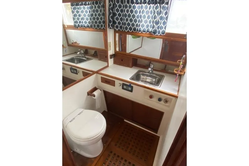 Slide: The Image of 1981 Grand Banks 36 Classic yacht bathroom with sink, toilet, and wooden cabinetry. - 39