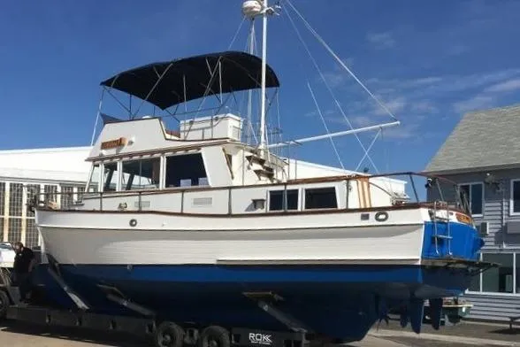 Slide: The Image of 1981 Grand Banks 36 Classic yacht on trailer, featuring white hull and blue bottom. - 7