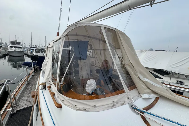 Slide: The Image of 1978 Robert Perry 47 sailboat docked in a marina, surrounded by other boats. - 14