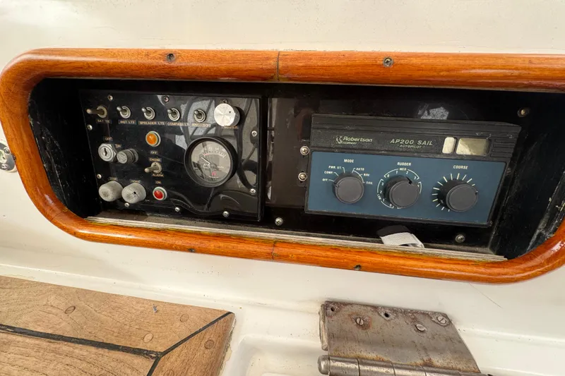 Slide: The Image of Small dog on a 1978 Robert Perry 47 sailboat with cushions and marina view. - 19