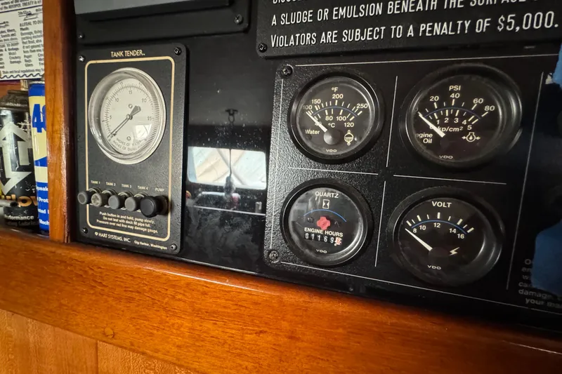 Slide: The Image of Engine compartment of a 1978 Robert Perry 47 yacht, featuring gauges and wiring. - 33