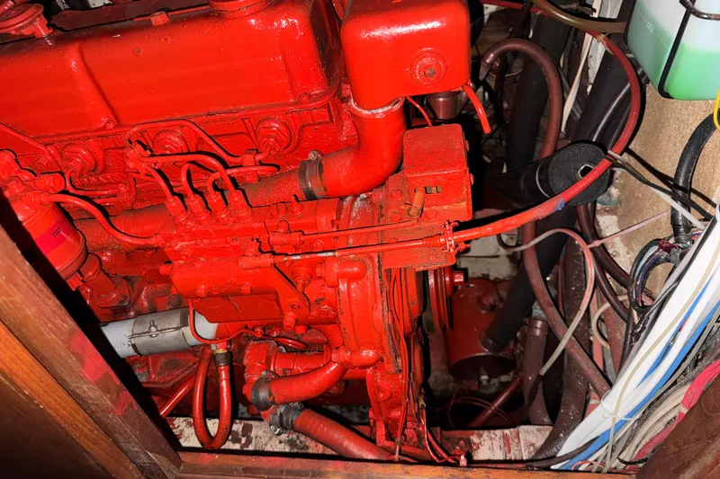 Slide: The Image of Red engine in a 1978 Robert Perry 47 sailboat, surrounded by cables and hoses. - 38