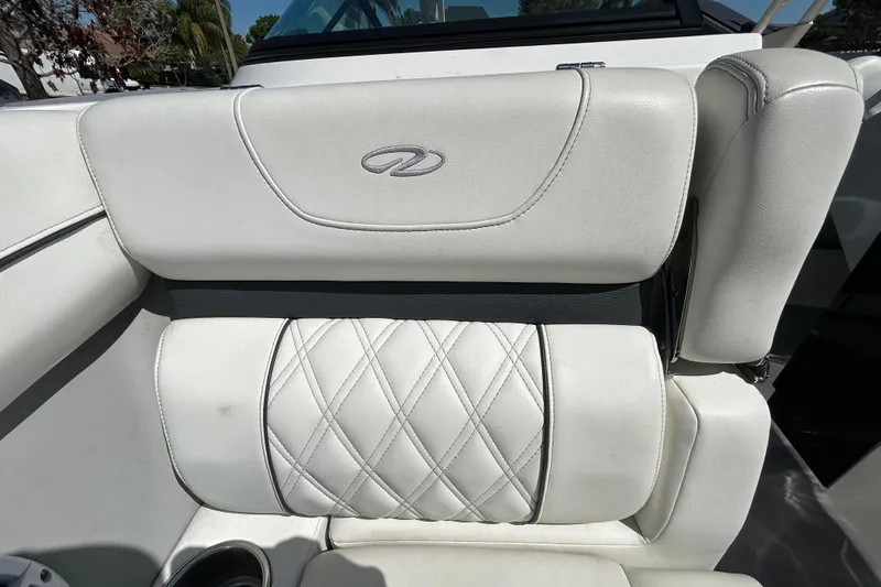 Slide: The Image of White leather seating in a 2022 Regal LS2 boat, featuring diamond stitching and logo. - 101