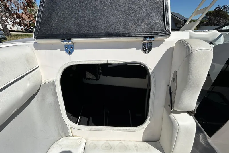 Slide: The Image of 2022 Regal LS2 boat storage compartment with open hatch and white seating. - 102