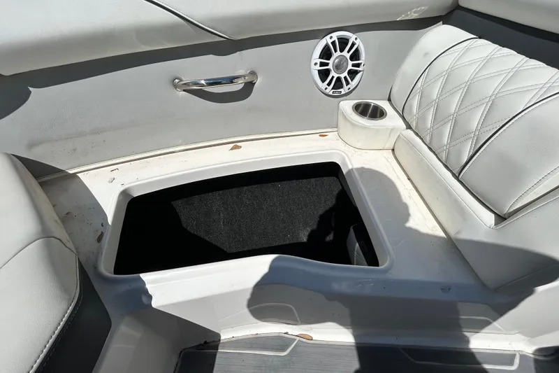 Slide: The Image of 2022 Regal LS2 boat interior with open storage, speaker, and cup holder. - 105