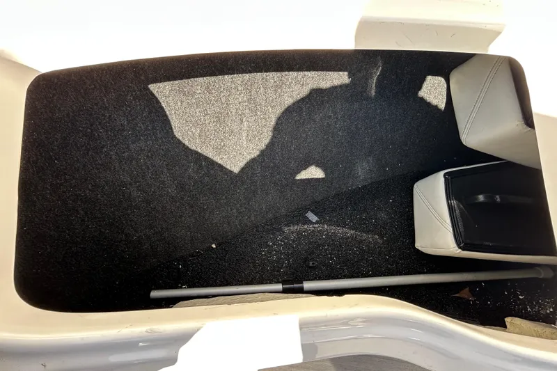 Slide: The Image of Storage compartment in a 2022 Regal LS2 boat, featuring carpeted interior and seating. - 106