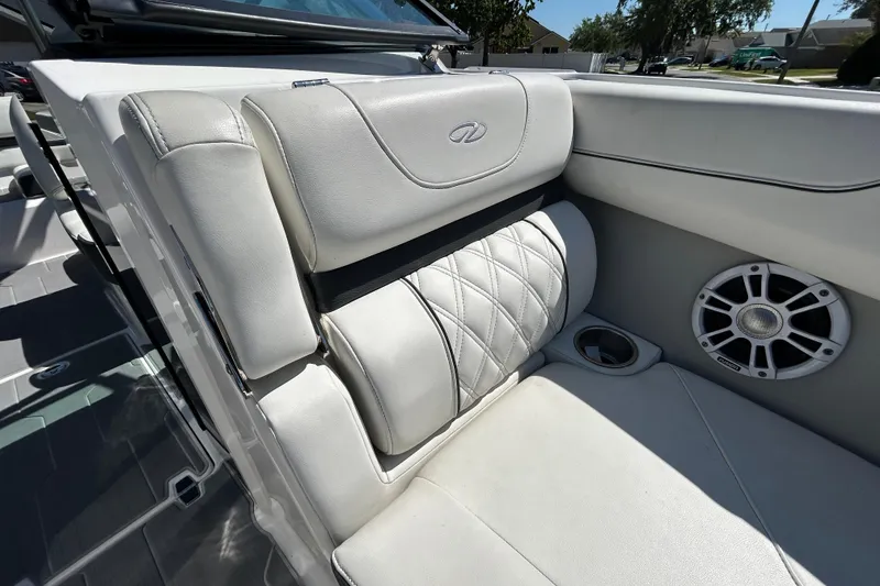 Slide: The Image of Luxurious white seating in a 2022 Regal LS2 boat, featuring quilted design and speaker. - 117