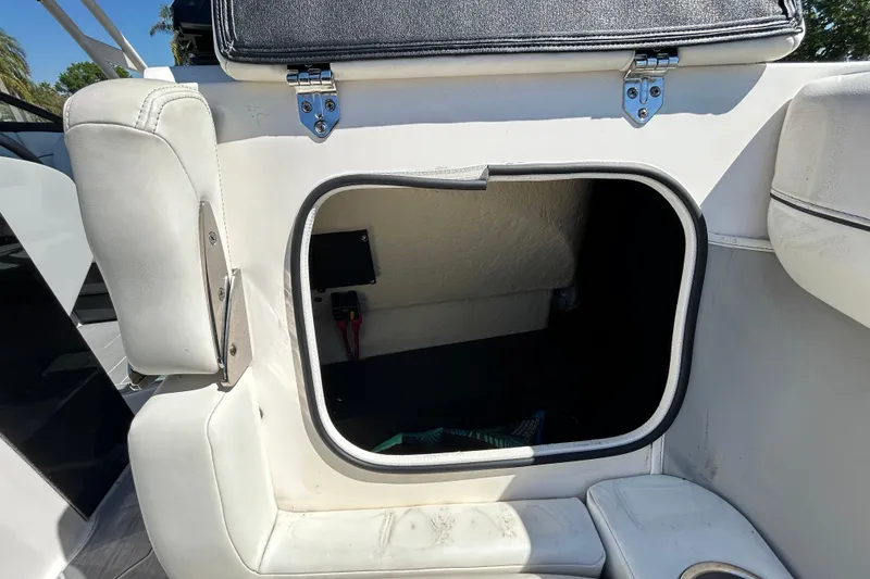 Slide: The Image of Open storage compartment on a 2022 Regal LS2 boat, featuring white upholstery. - 120