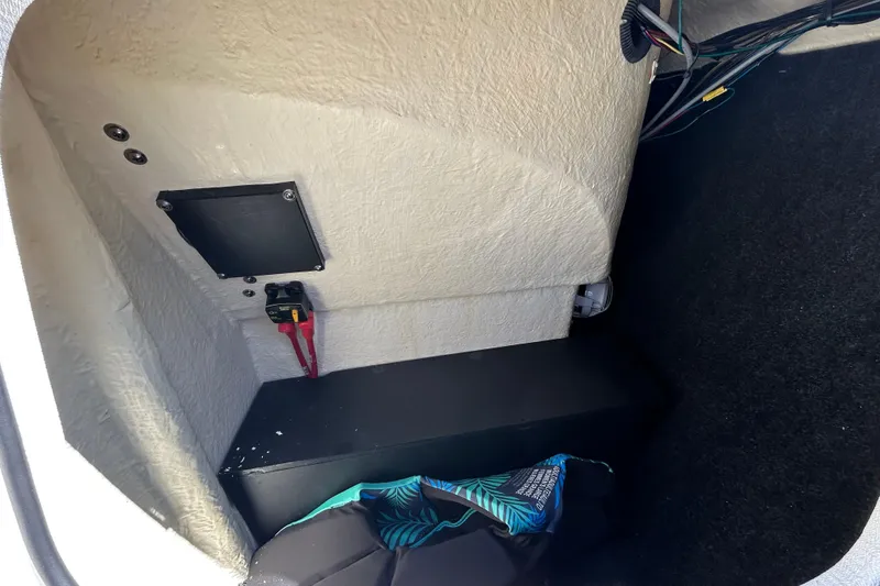 Slide: The Image of 2022 Regal LS2 boat storage compartment with wiring and battery switch. - 121