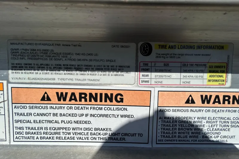Slide: The Image of Warning labels and tire information on a 2022 Regal LS2 trailer. - 125