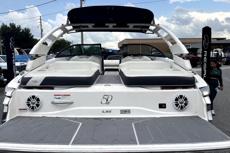 Slide: The Image of 2022 Regal LS2 boat with white seating and speakers, displayed outdoors. - 2