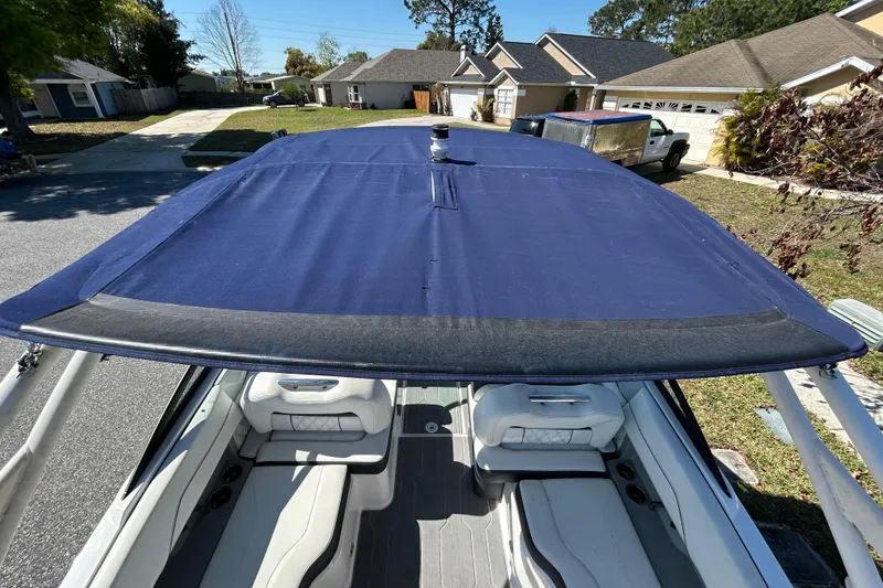 Slide: The Image of 2022 Regal LS2 boat with blue canopy, parked in residential area. - 24