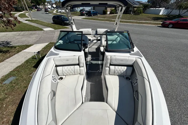 Slide: The Image of 2022 Regal LS2 boat with luxurious seating, parked on a suburban street. - 32