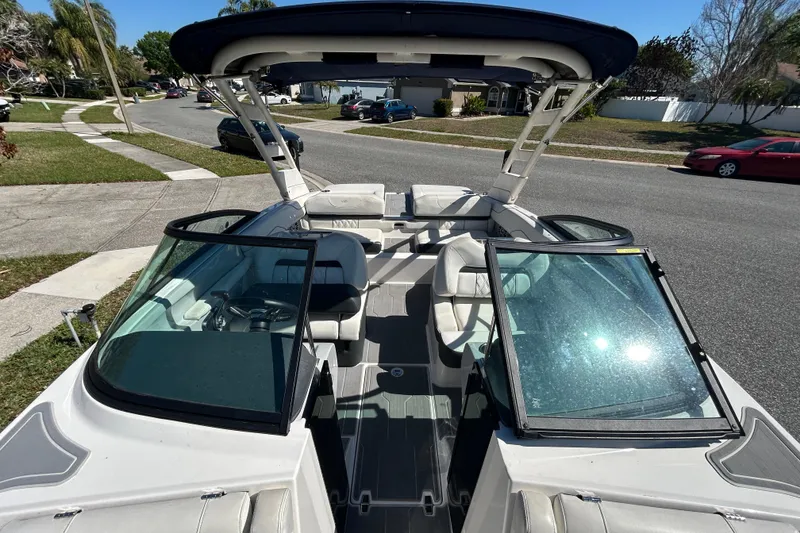 Slide: The Image of 2022 Regal LS2 boat with open cockpit and seating, parked on a residential street. - 34