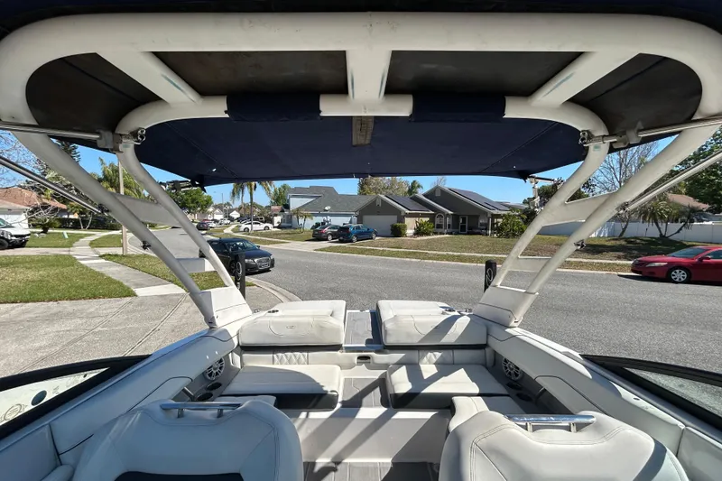 Slide: The Image of 2022 Regal LS2 boat interior with canopy, parked in suburban neighborhood. - 38