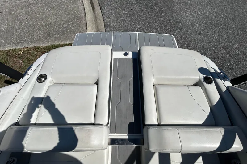 Slide: The Image of 2022 Regal LS2 boat with white cushioned seats and cup holders on a sunny day. - 42