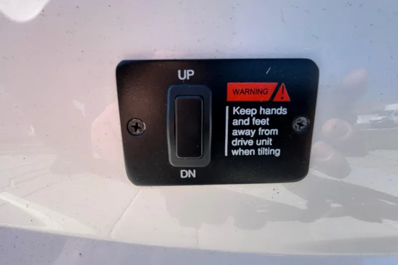 Slide: The Image of Tilt control switch with warning label on 2022 Regal LS2 boat. - 45