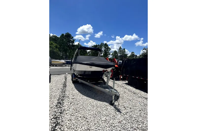 Slide: The Image of 2022 Regal LS2 boat on trailer, parked on gravel under a clear blue sky. - 5