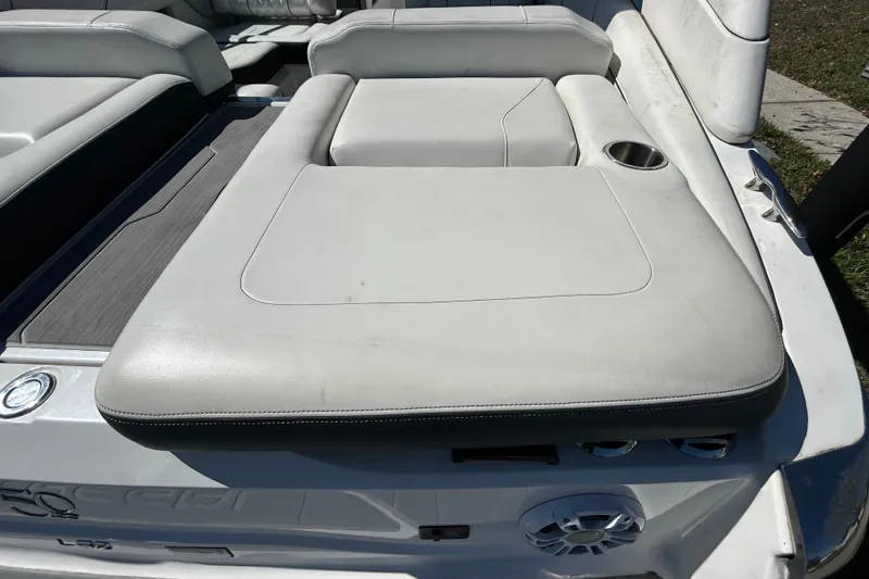 Slide: The Image of 2022 Regal LS2 boat with white cushioned seating and cup holder on deck. - 51