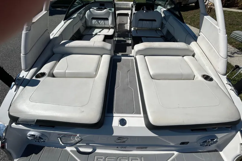 Slide: The Image of 2022 Regal LS2 boat interior with white seating and cup holders. - 54