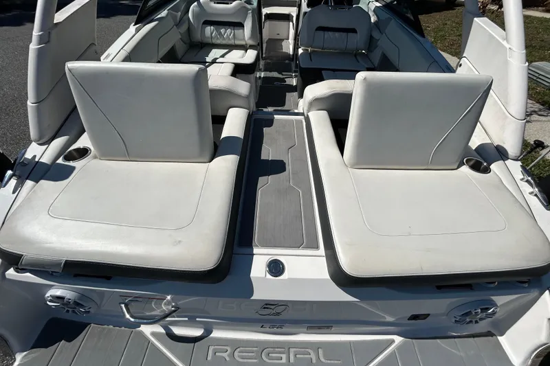 Slide: The Image of 2022 Regal LS2 boat interior with white seating and cup holders. - 55