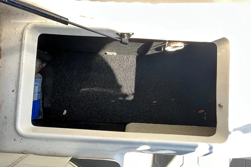 Slide: The Image of Open storage compartment in 2022 Regal LS2 boat, showing interior space and carpet lining. - 58