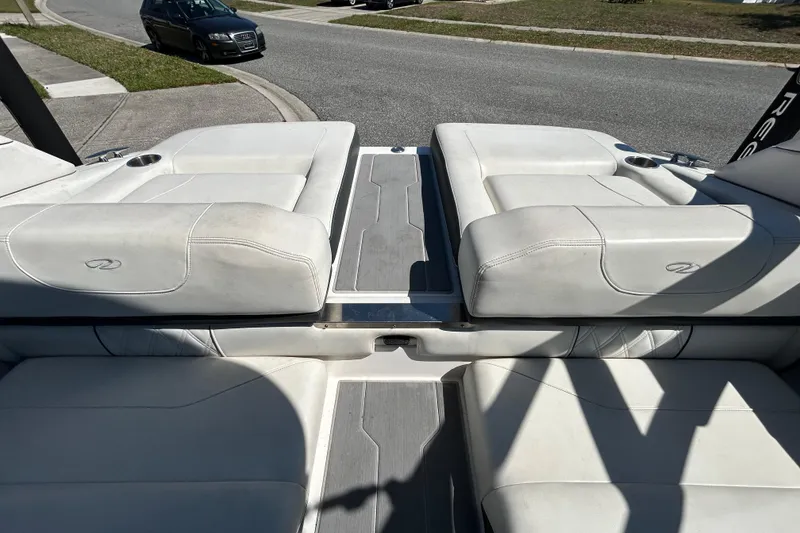 Slide: The Image of 2022 Regal LS2 boat interior with white seating and cup holders. - 60