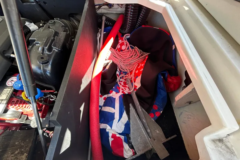 Slide: The Image of Engine compartment of a 2022 Regal LS2 boat with equipment and storage items. - 66