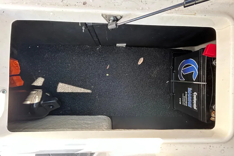 Slide: The Image of 2022 Regal LS2 boat storage compartment with marine battery and accessories. - 70