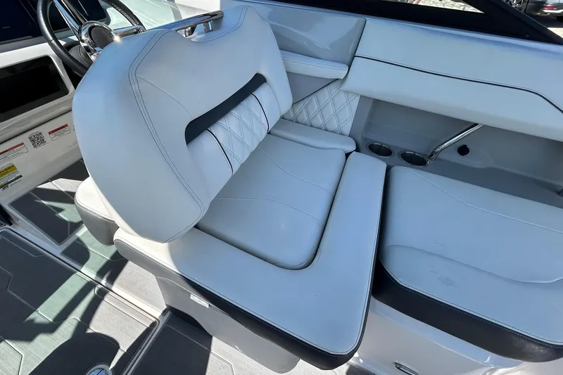 Slide: The Image of Interior of a 2022 Regal LS2 boat featuring luxurious white seating and modern dashboard. - 77
