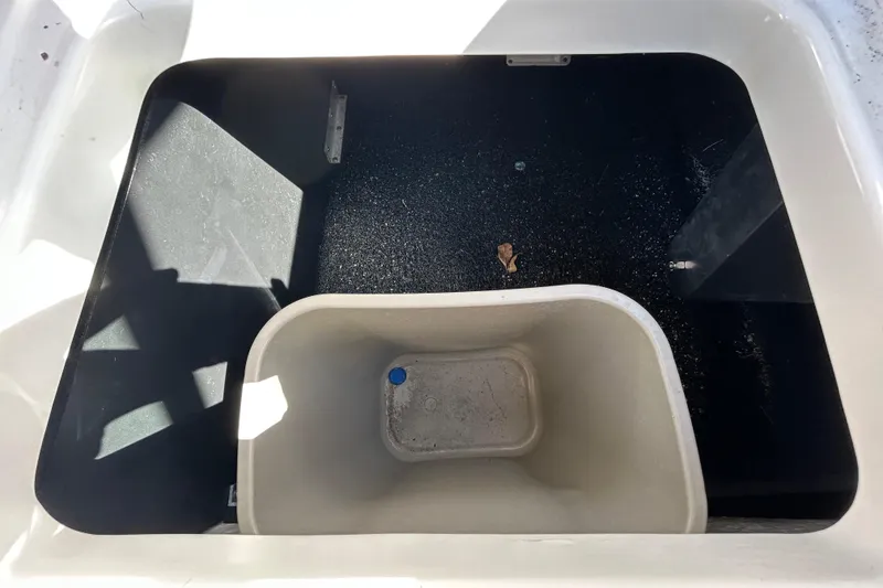 Slide: The Image of Storage compartment of a 2022 Regal LS2 boat with a removable bin. - 85