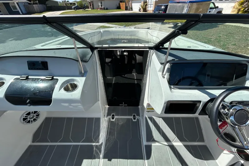 Slide: The Image of 2022 Regal LS2 boat interior with steering wheel, dashboard, and seating area. - 87